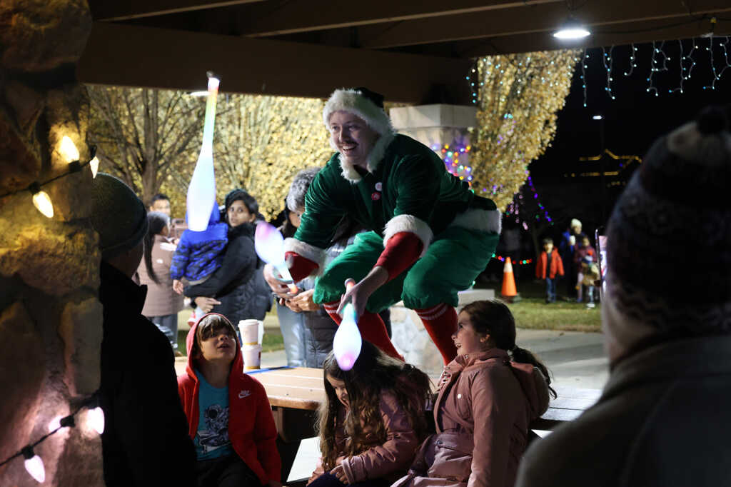 Kids being entertained by a man dressed as an elf